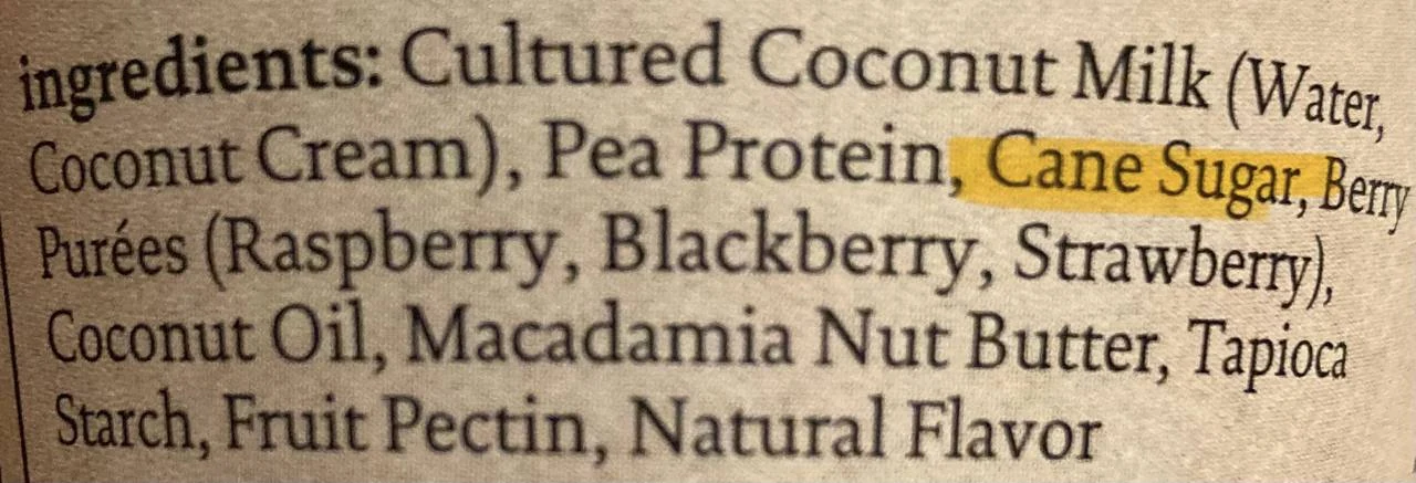 Close-up of a plant-based yogurt ingredient label showing added sugar in the list